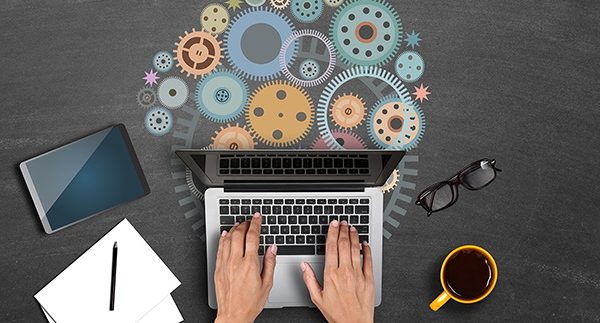 High angle view of a businessman hands using laptop with gears. Concepts of collaboration and progress.